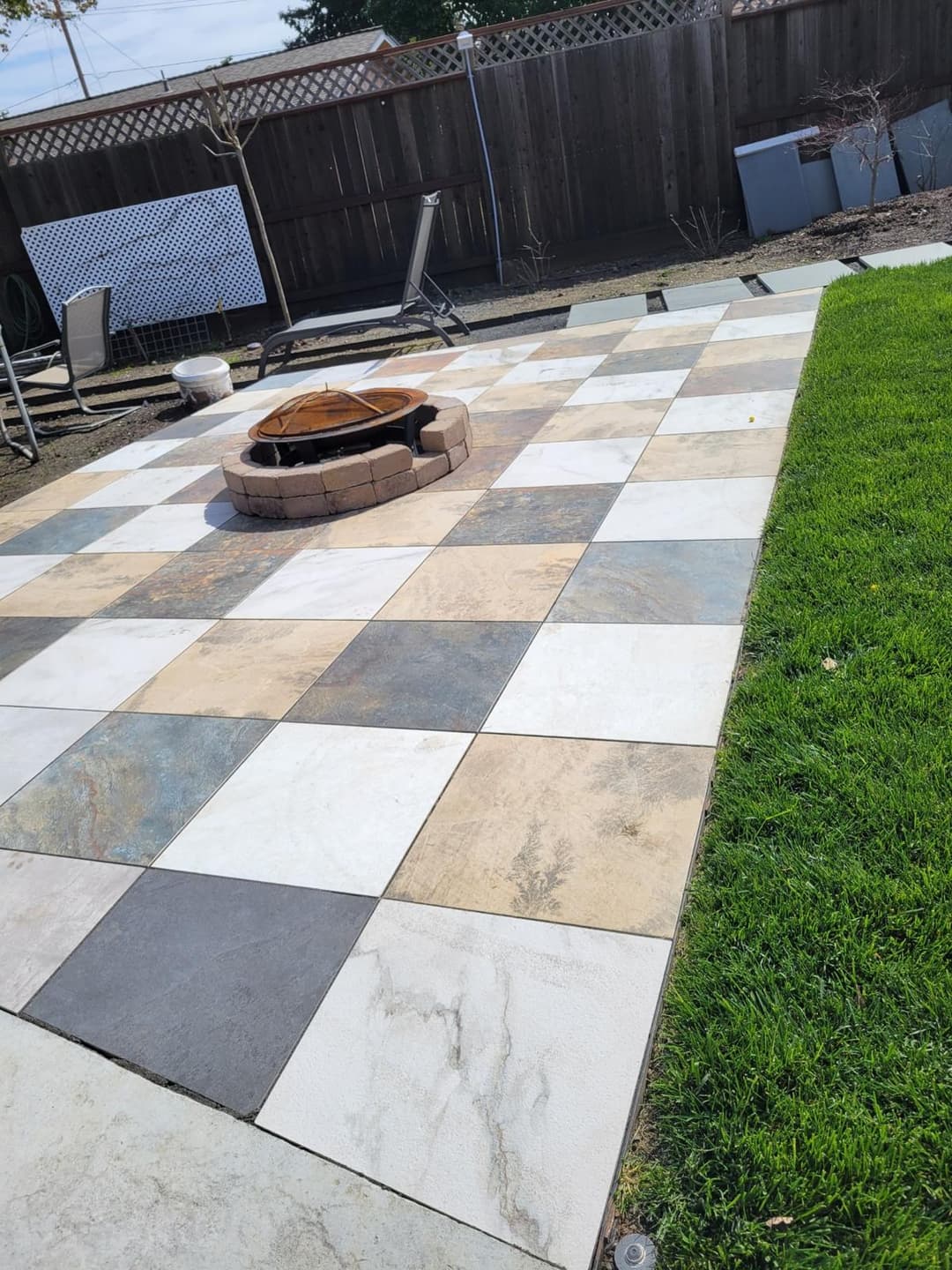 picture of a backyard with pavers and a paver firepit